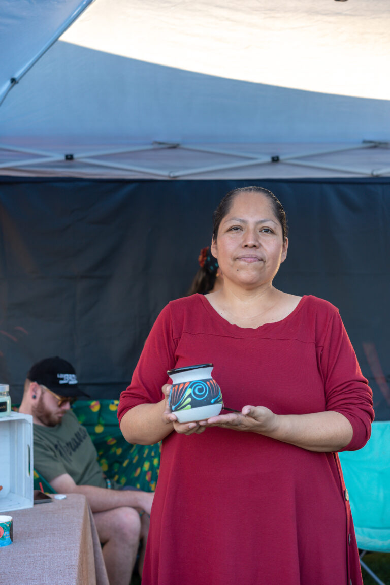 Latina entrepreneur at her Mujeres Mercado booth